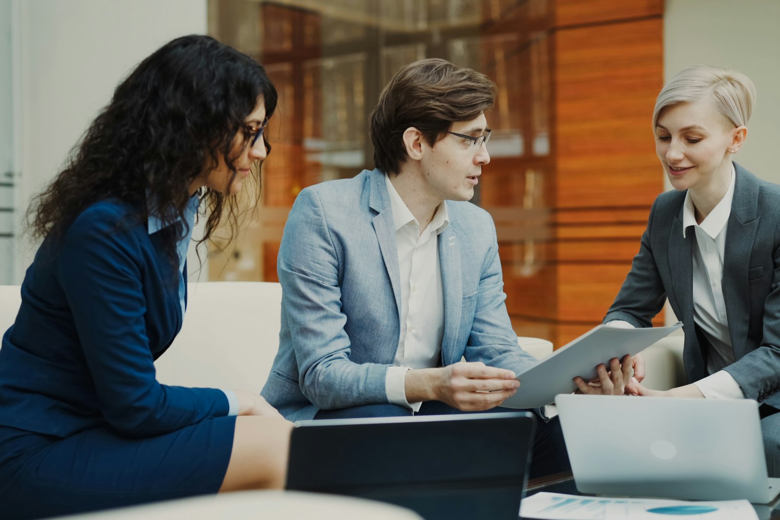 Three business professionals reviewing documents together at a table