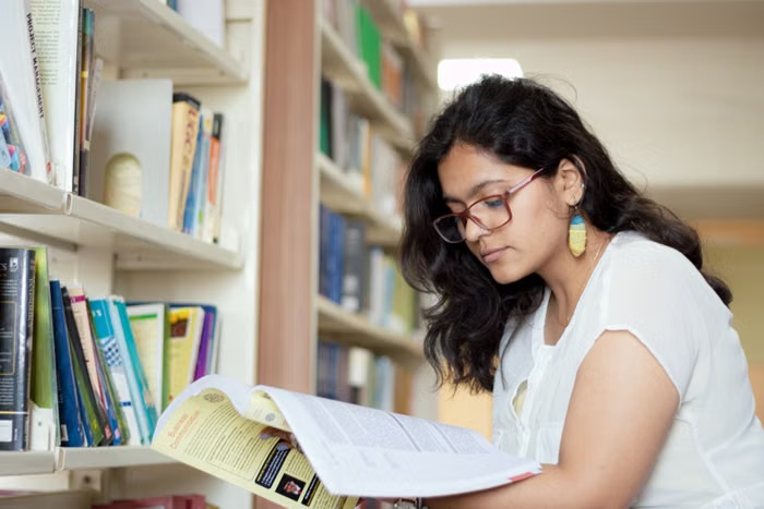 Student reading a book in a library