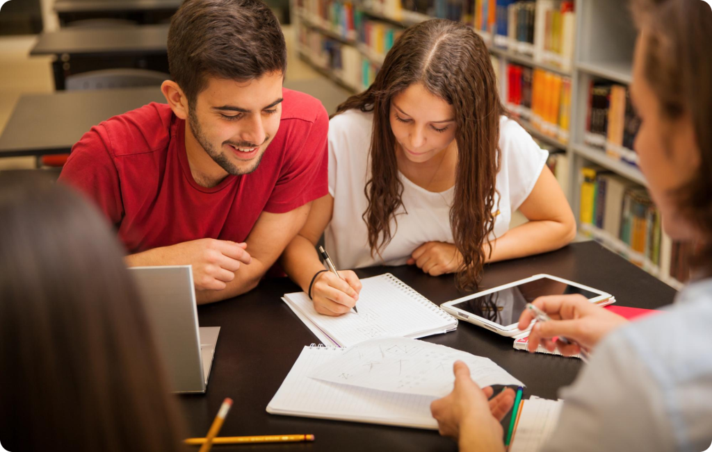Students taking notes together at a library table